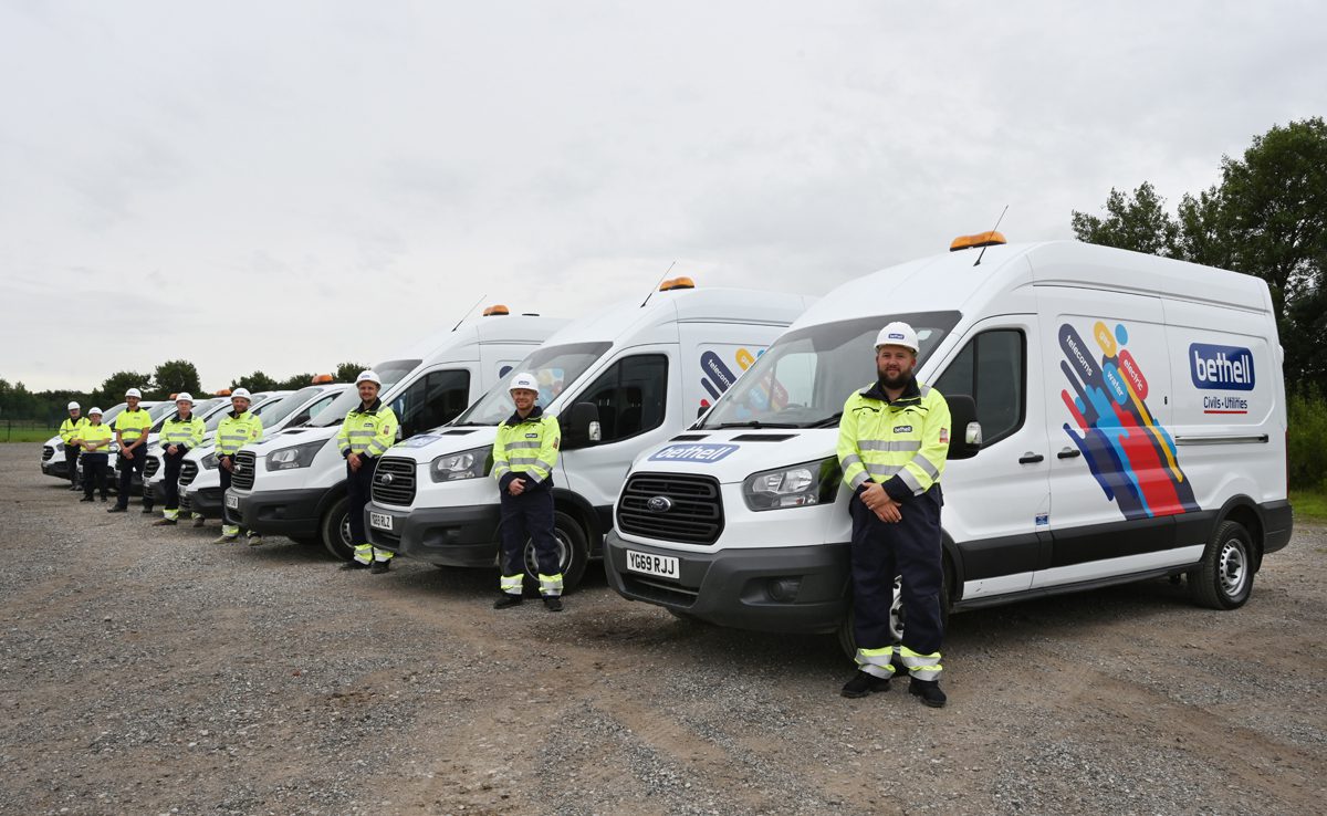 A group of Bethell utility operatives line-up in front of Bethell vans