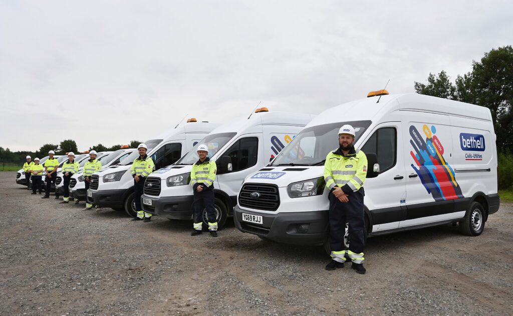 A group of utility operatives standing side by side next to Bethell vans