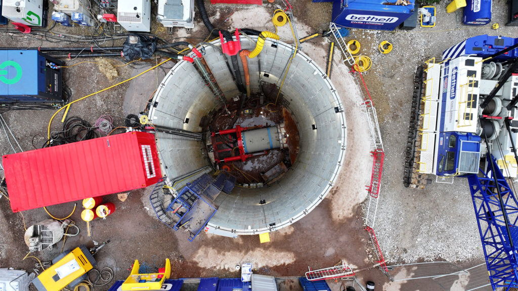 Top down view of a shaft where pipes are being installed undeground